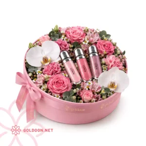 باکس گل و هدیه کد 035 رنگ صورتی با رز و میخک صورتی، ارکیده فالانوپسیس سفید و لیپ‌گلاس کیکو میلانو