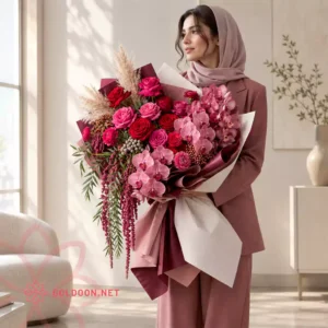 دسته گل رز و ارکیده صورتی کد 015 با رز قرمز و صورتی، ارکیده و پمپاس در بسته‌بندی کرم و بورگاندی در دستان مدل خانم